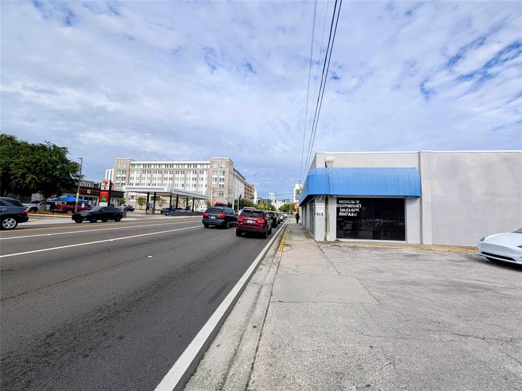 A street view shows a commercial building with a blue awning next to a busy road — 915 S ORANGE AVENUE, ORLANDO, FL