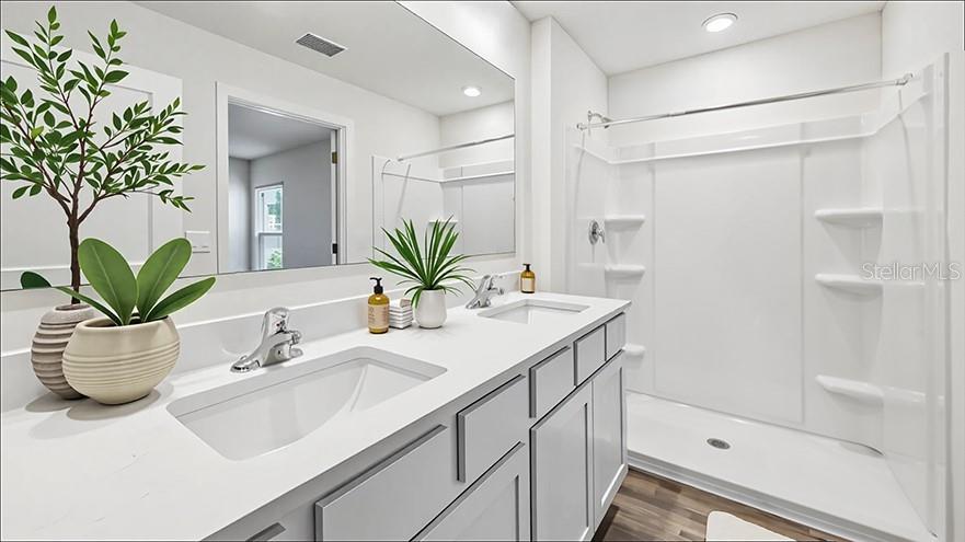 A modern bathroom features a white vanity with a sink, mirror, and walk-in shower — 24317 NW 10TH ROAD, NEWBERRY, FL