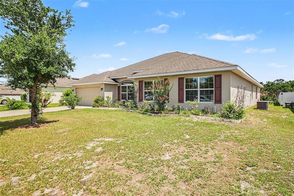 A single-story house with a tan exterior, brown shutters, and a two-car garage — 503 W LEAH COURT, FRUITLAND PARK, FL