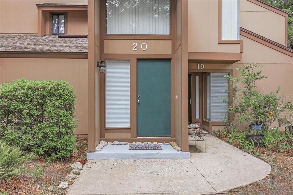The exterior of a multi-unit building shows two adjacent front entrances with brown trim — 20 MASTERS COURT UNIT 20, PALM COAST, FL