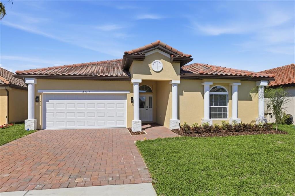 A single-story house with a tiled roof, white columns, and a brick paver driveway — 367 VILLA SORRENTO CIRCLE, HAINES CITY, FL