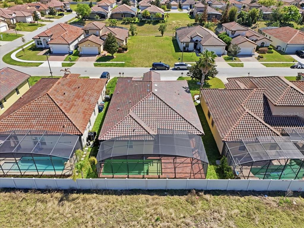 An aerial view shows three suburban houses with screened-in pools and tile roofs — 367 VILLA SORRENTO CIRCLE, HAINES CITY, FL