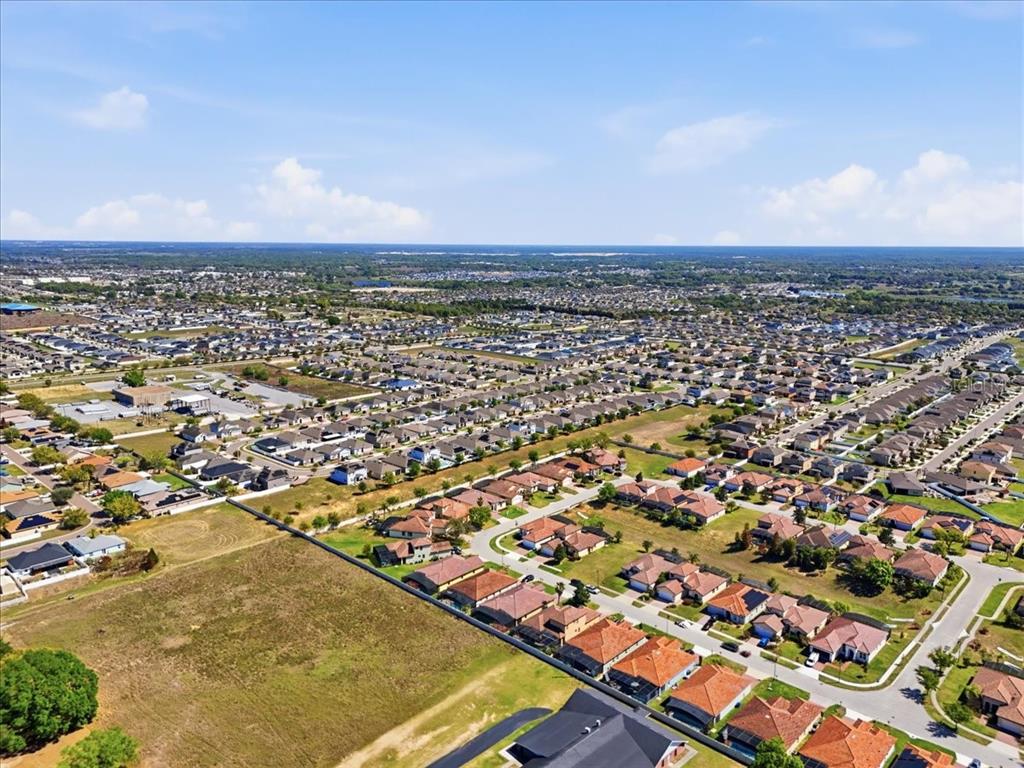 An aerial view shows a suburban neighborhood with many houses and undeveloped land — 367 VILLA SORRENTO CIRCLE, HAINES CITY, FL