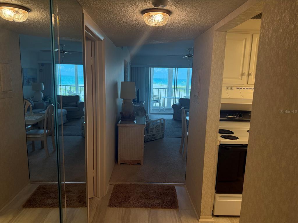 A view from a hallway looking into a living area with a balcony overlooking the ocean — 1400 TARPON CENTER DRIVE UNIT 202, VENICE, FL