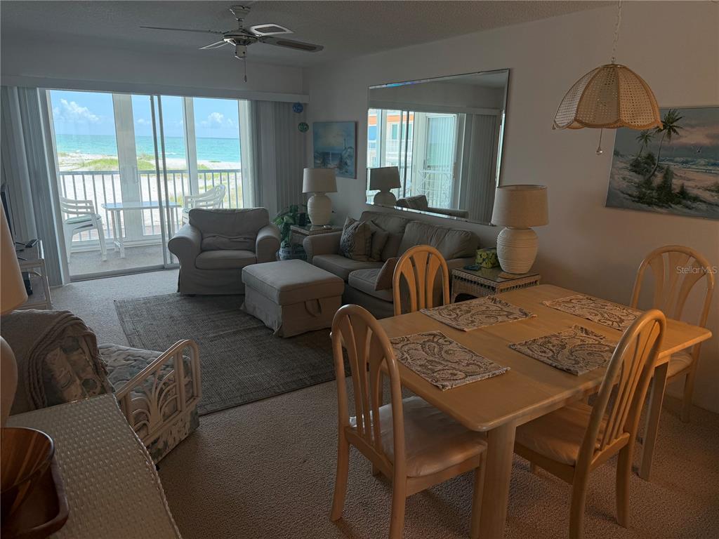 A living and dining area features a beach view, beige carpeting, and neutral furniture — 1400 TARPON CENTER DRIVE UNIT 202, VENICE, FL