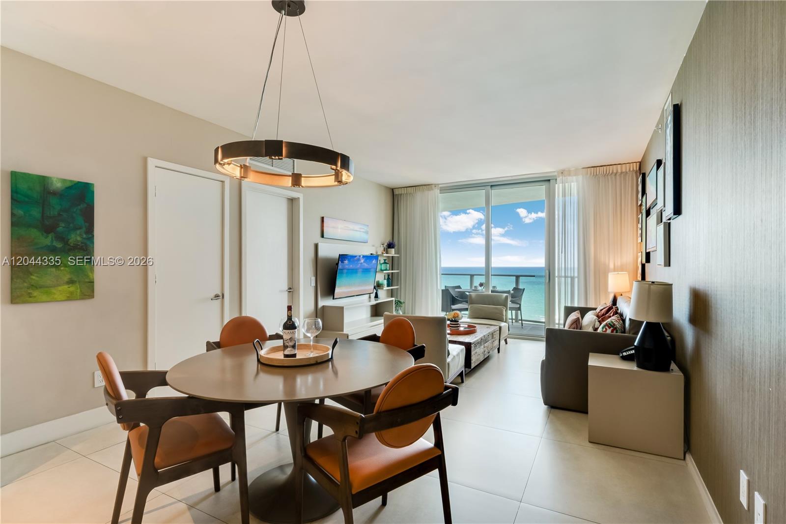 A dining area and living room feature modern furniture, tile floors, and a balcony view — 4111 S Ocean Dr # 1405, Hollywood FL 33019, HOLLYWOOD, FL
