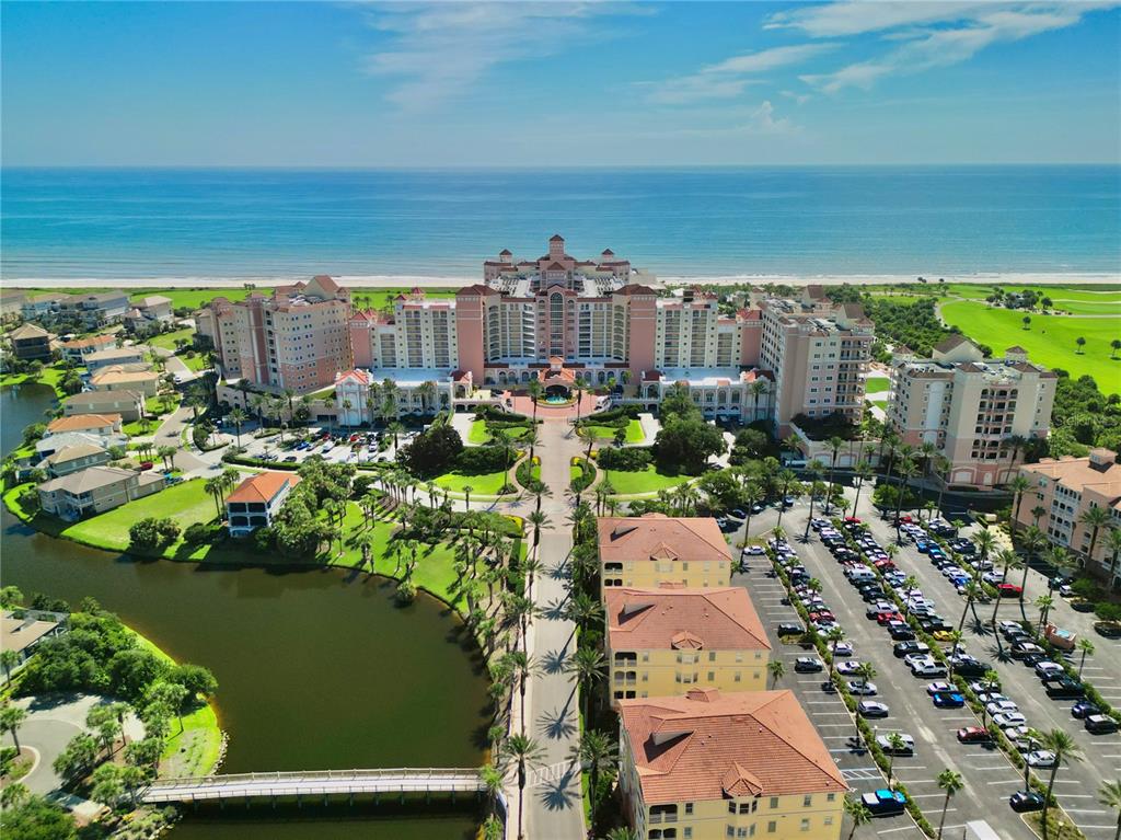 An aerial view of a large beachfront resort complex with surrounding parking and a lake — 200 OCEAN CREST DRIVE UNIT 408, PALM COAST, FL