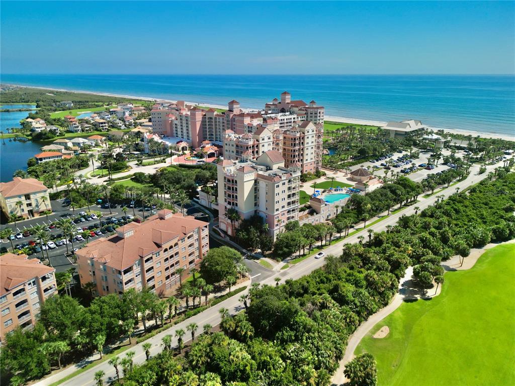 An aerial view shows a large coastal resort complex with multiple buildings, pools, and parking — 200 OCEAN CREST DRIVE UNIT 408, PALM COAST, FL