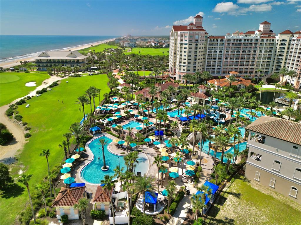 An aerial view shows a large resort complex with multiple swimming pools and a golf course — 200 OCEAN CREST DRIVE UNIT 408, PALM COAST, FL