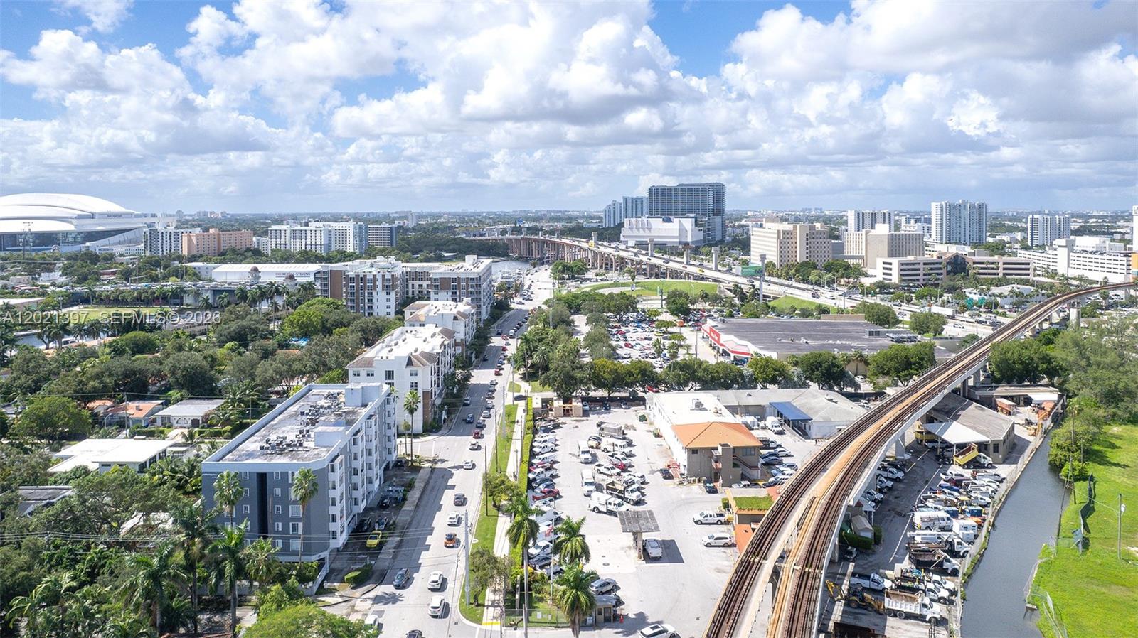 An aerial view shows a city street, apartment buildings, a parking lot, and elevated train tracks — 1010 NW 11th St # 507, Miami FL 33136, MIAMI, FL