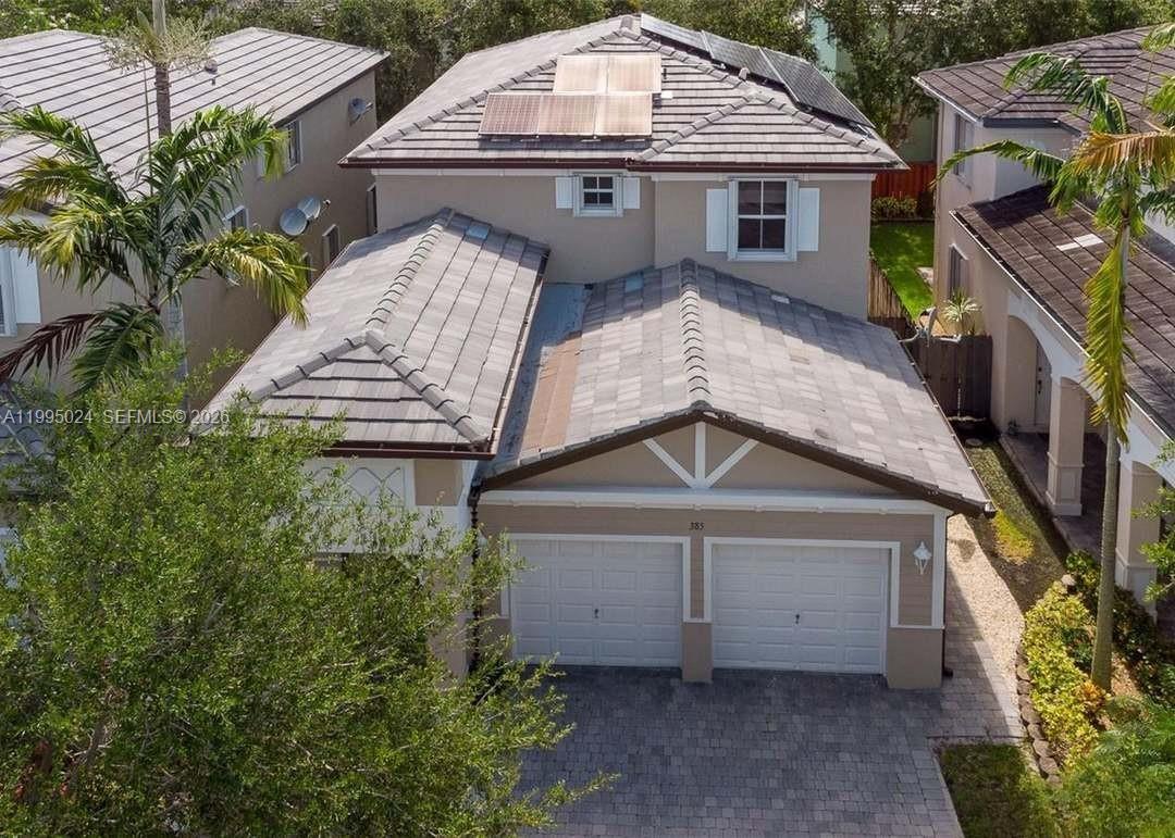 An aerial view of a two-story house with a tiled roof and two-car garage — 385 NE 36th Ave Rd, Homestead FL 33033, HOMESTEAD, FL