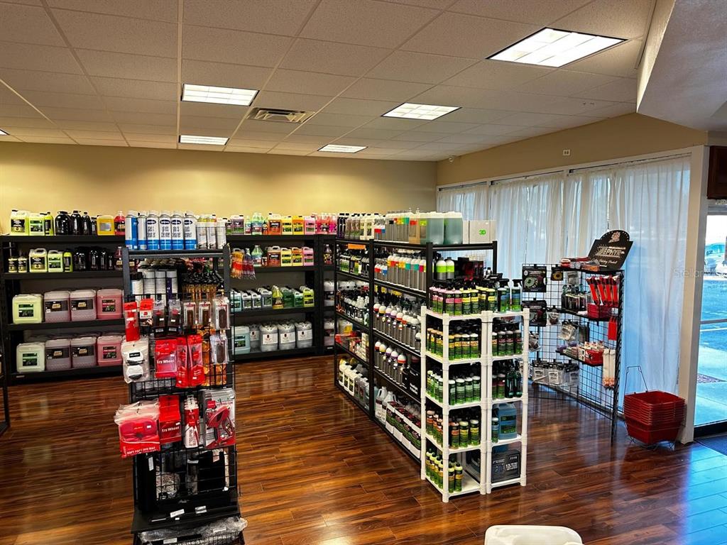 A retail store interior features shelves stocked with automotive cleaning products and wood-look flooring — 3701 N JOHN YOUNG PARKWAY, ORLANDO, FL