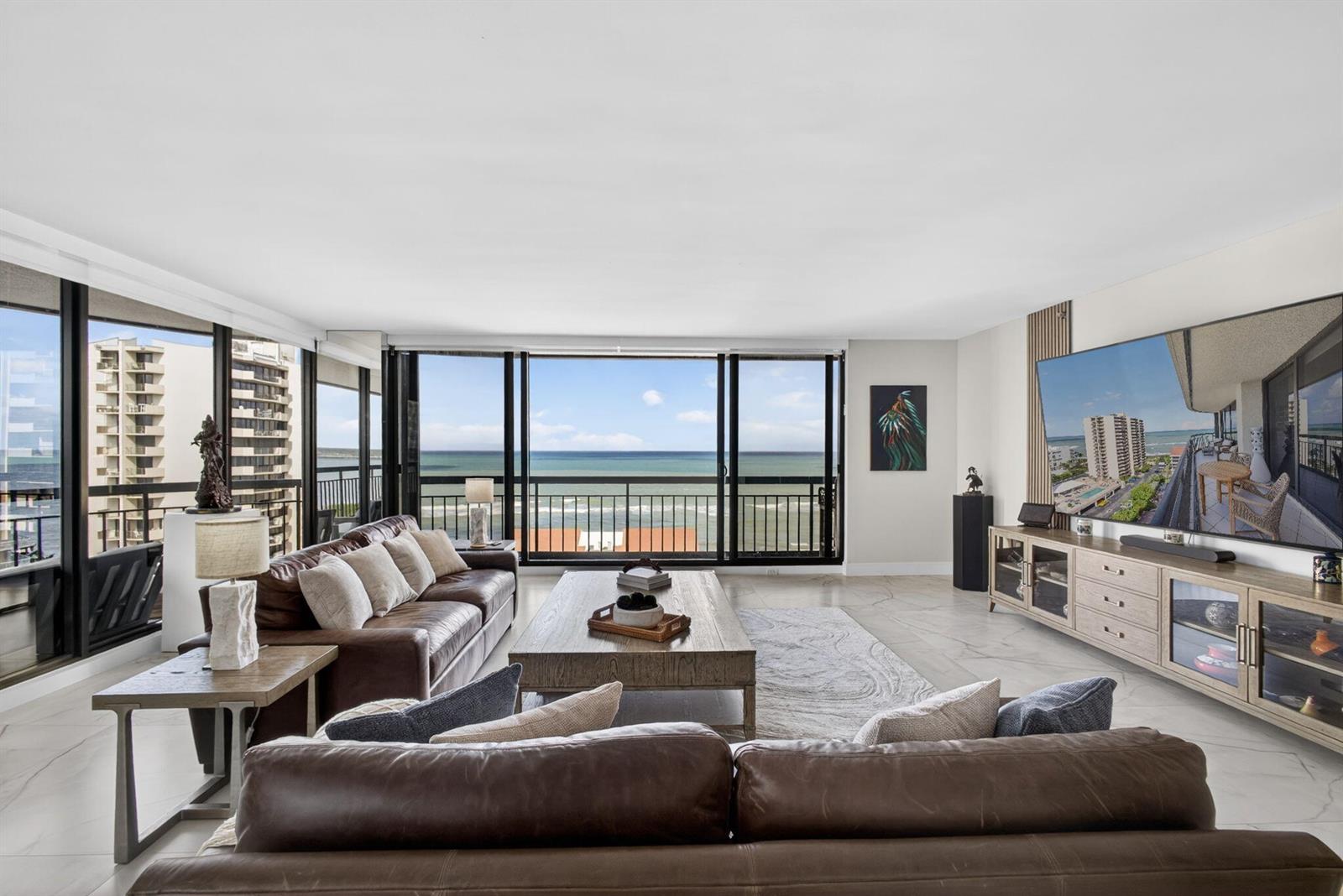 A living room features two brown leather sofas, a wooden coffee table, and ocean views — 4100 N Ocean Drive # 1201, Singer Island FL 33404, SINGER ISLAND, FL