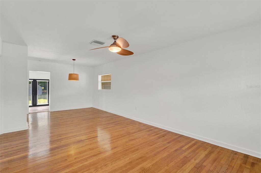 An empty room with hardwood floors, a ceiling fan, and a doorway leading outside — 3345 LILA DRIVE, ORLANDO, FL