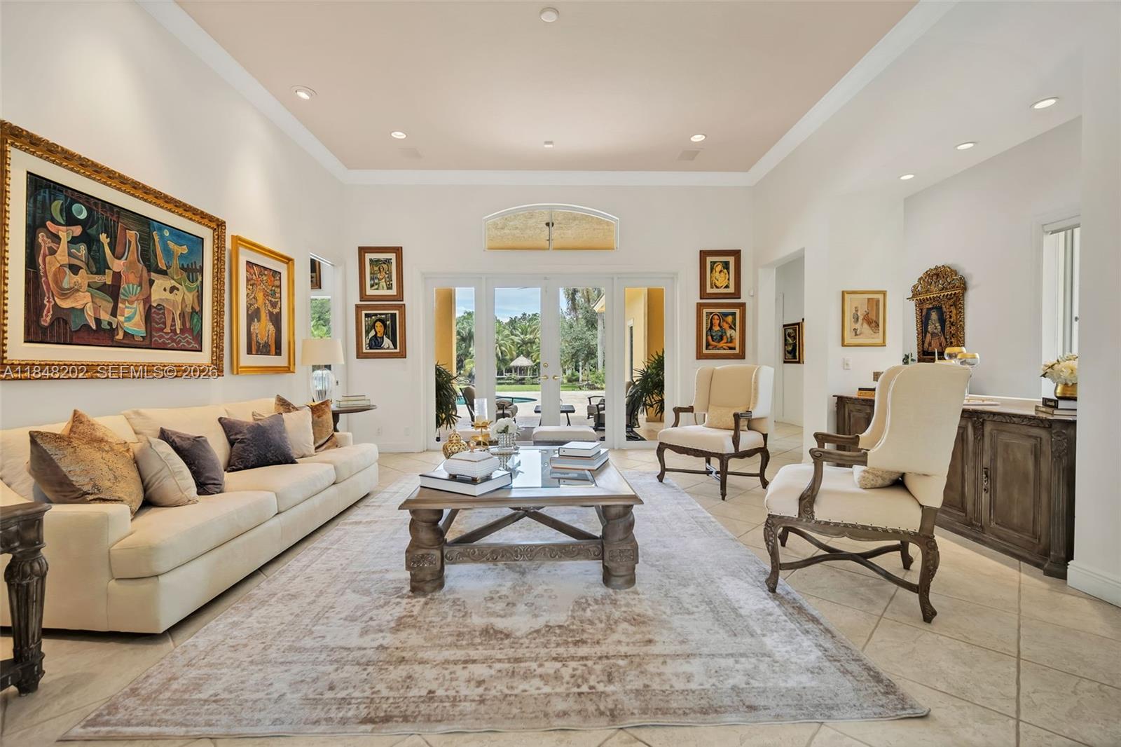 A bright living room features a cream sofa, two armchairs, a coffee table, and artwork — 14211 Sunset Ln, Southwest Ranches FL 33330, SOUTHWEST RANCHES, FL