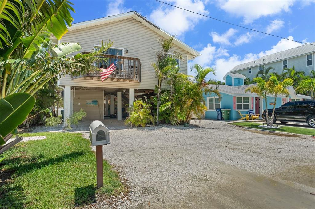 A two-story house with a gravel driveway and a smaller blue cottage next door — 2517 AVENUE C, BRADENTON BEACH, FL
