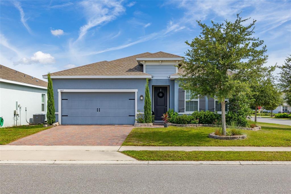 A blue single-story house with a two-car garage and a paved driveway — 367 AUGUST FERN LOOP, MOUNT DORA, FL