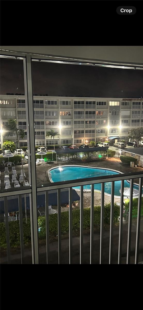 A view from a balcony overlooking a swimming pool and a multi-story apartment building — 329 SE 3rd St # 405T, Hallandale Beach FL 33009, HALLANDALE BEACH, FL