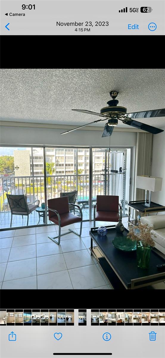 A living room with tile floors, a ceiling fan, and sliding doors leading to a balcony — 329 SE 3rd St # 405T, Hallandale Beach FL 33009, HALLANDALE BEACH, FL