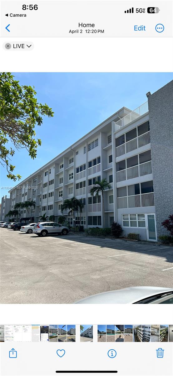 A multi-story apartment building with screened balconies sits adjacent to a paved parking lot — 329 SE 3rd St # 405T, Hallandale Beach FL 33009, HALLANDALE BEACH, FL