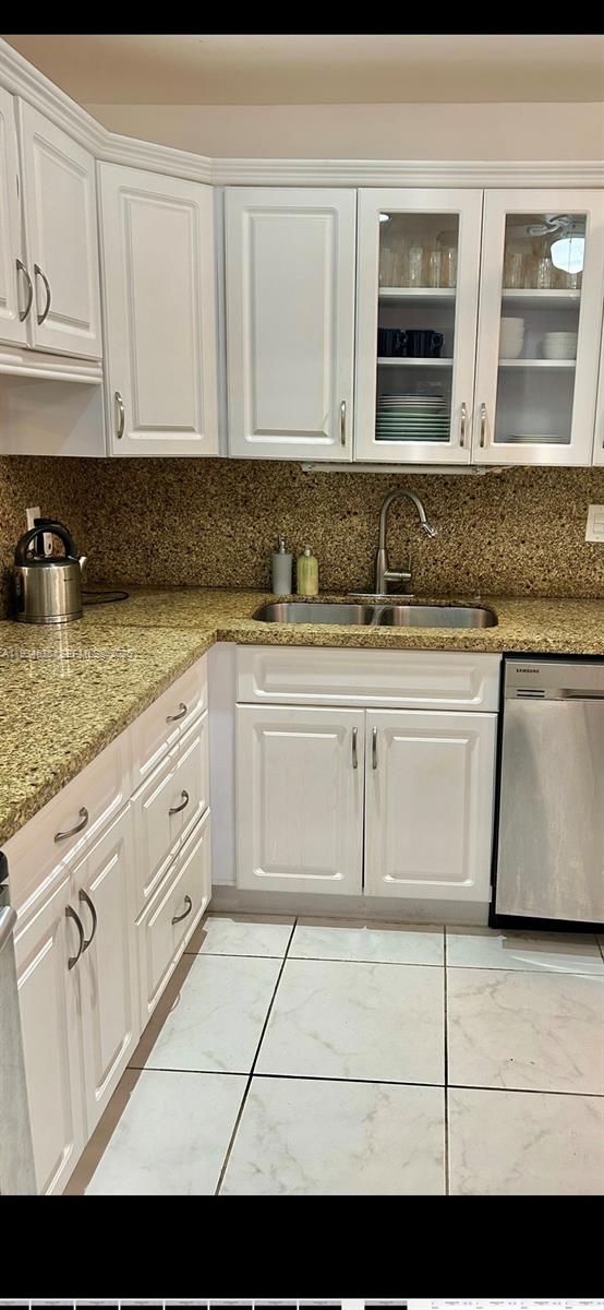 A kitchen features white cabinetry, granite countertops, a double sink, and light-colored tile flooring — 329 SE 3rd St # 405T, Hallandale Beach FL 33009, HALLANDALE BEACH, FL