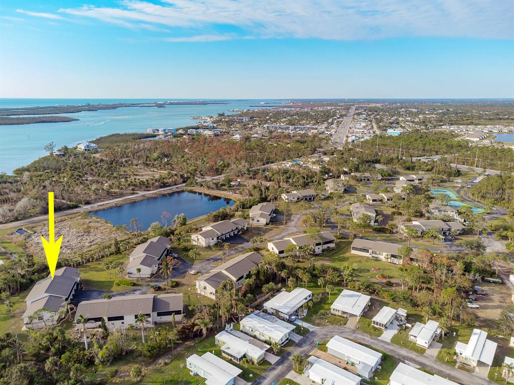 An aerial view shows a residential complex with a yellow arrow pointing to a building — 4260 PLACIDA ROAD UNIT 12C, ENGLEWOOD, FL