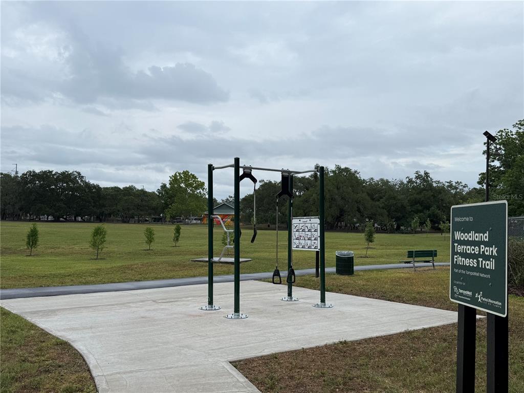 An outdoor fitness station with exercise equipment sits on a concrete pad at a park — 3210 E FERN STREET, TAMPA, FL