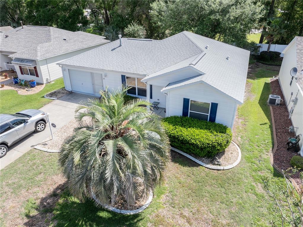 An aerial view shows a white single-story house with a palm tree in the front yard — 16980 SE 96TH CHAPELWOOD CIRCLE, THE VILLAGES, FL