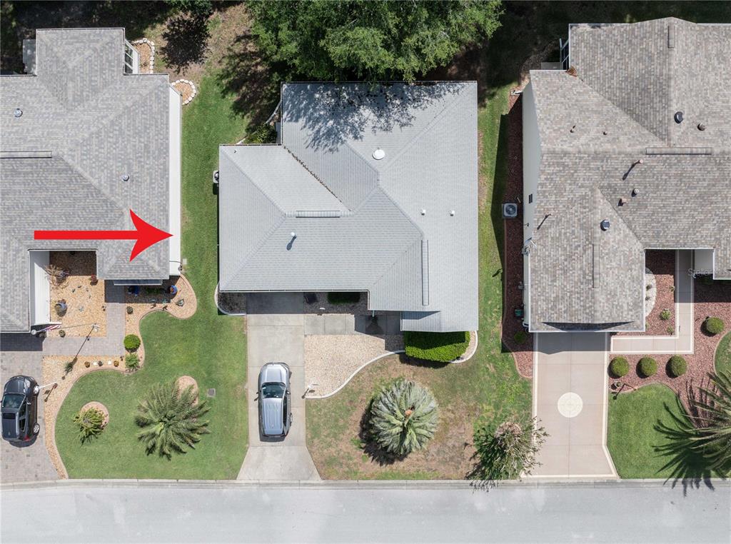 This aerial view shows three suburban houses with driveways and lawns, one outlined in red — 16980 SE 96TH CHAPELWOOD CIRCLE, THE VILLAGES, FL