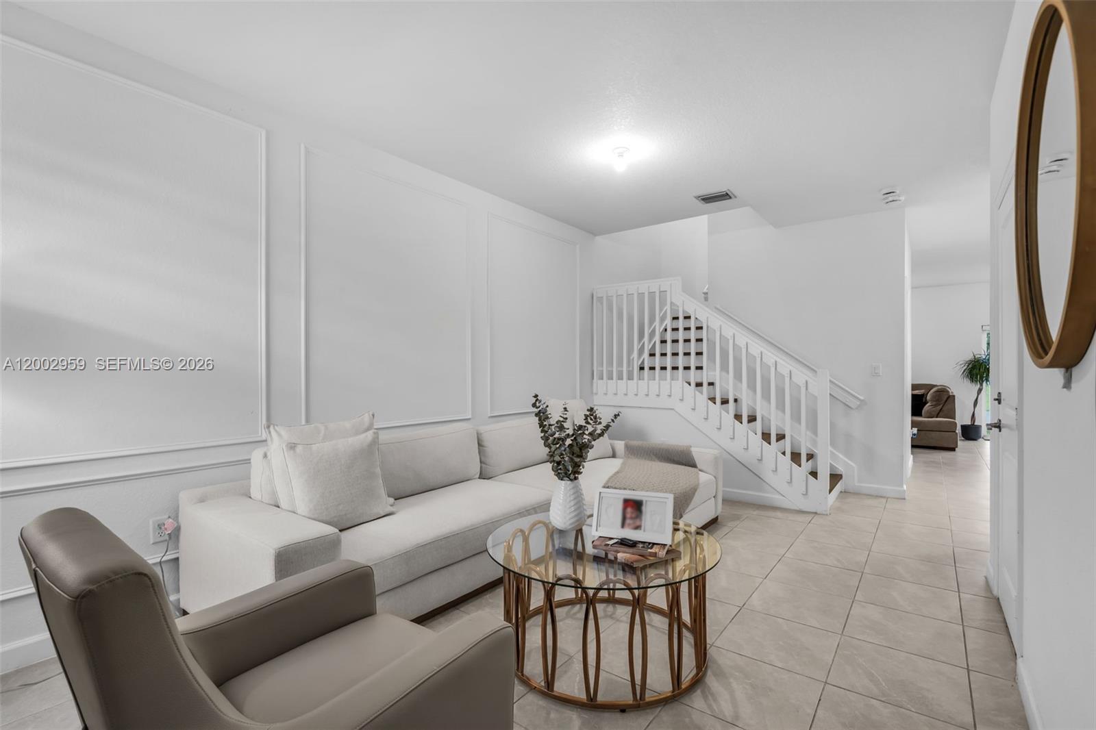A living room features a white sectional sofa, a glass coffee table, and a staircase — 12586 NW 22nd Pl, Miami FL 33167, MIAMI, FL