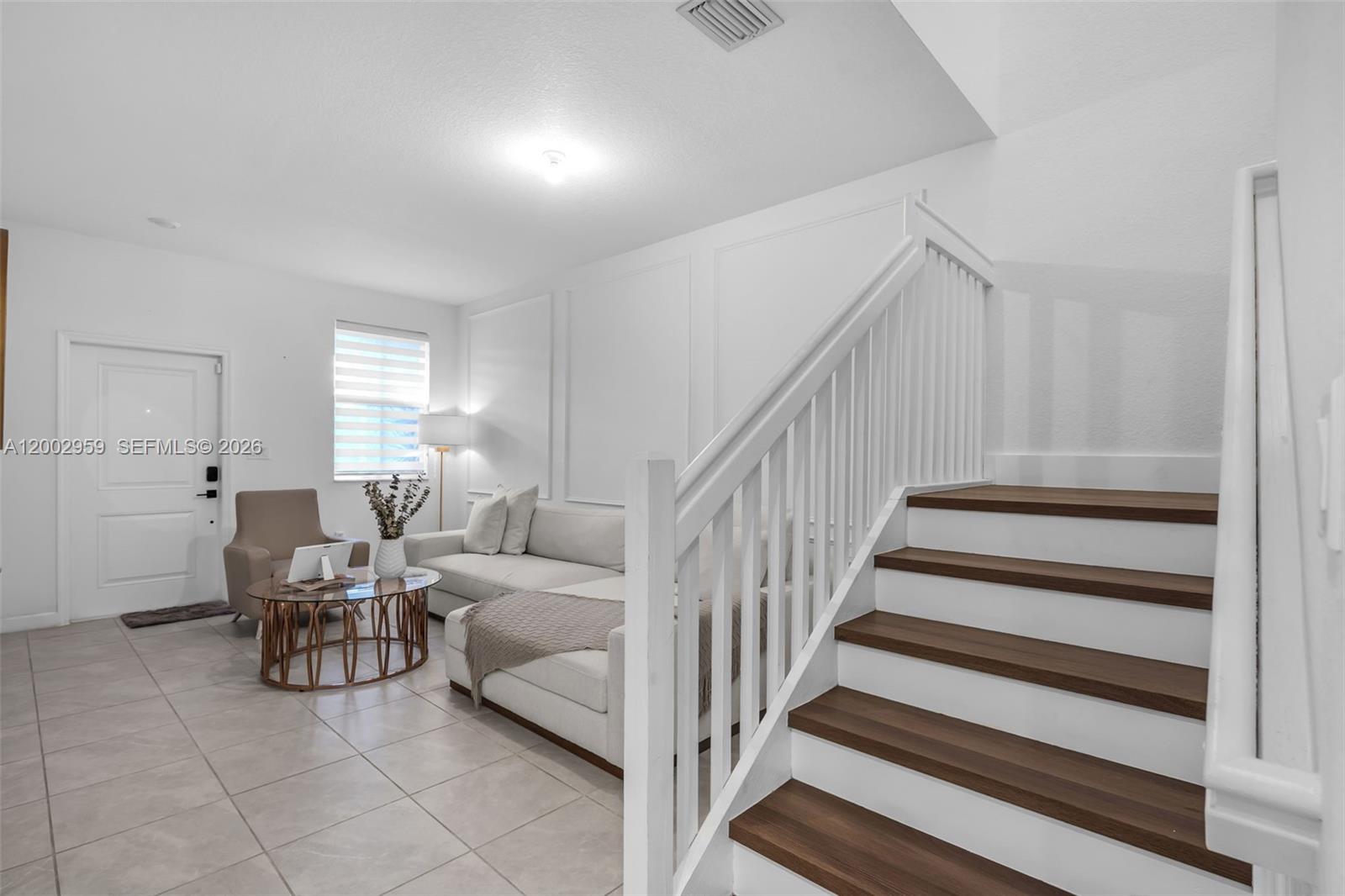 A living room features a staircase with wood treads, white walls, and tile flooring — 12586 NW 22nd Pl, Miami FL 33167, MIAMI, FL