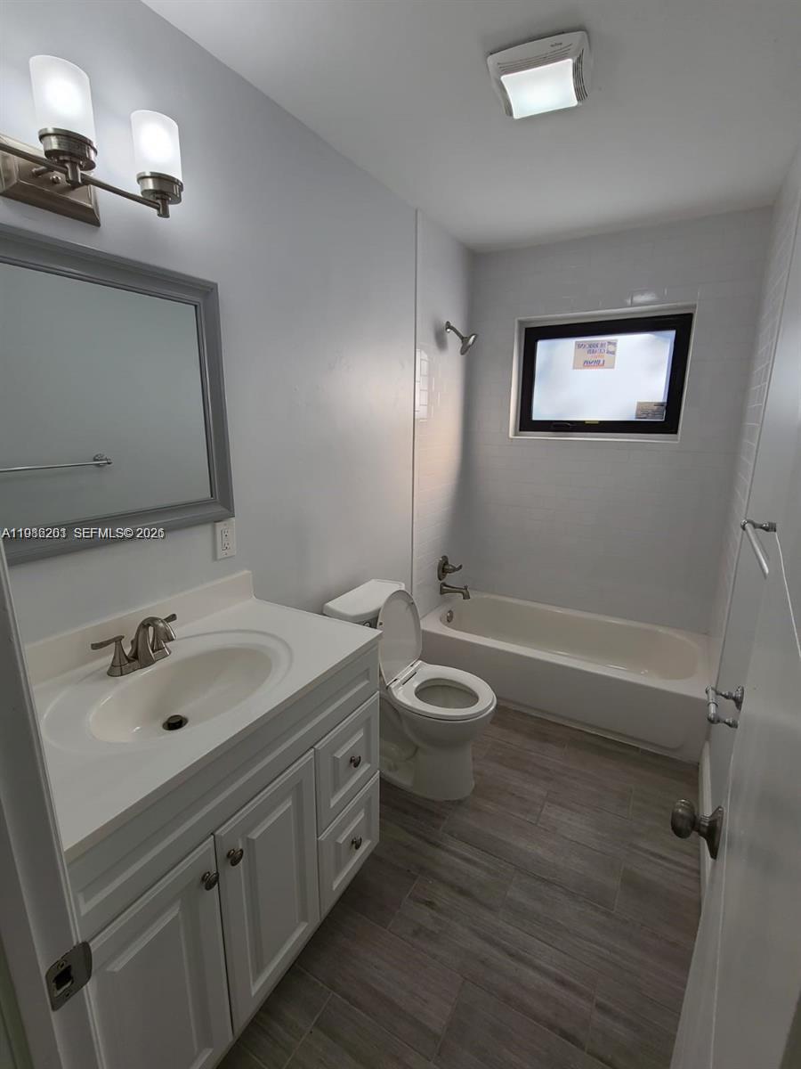 A bathroom features a white vanity, a toilet, and a bathtub with white subway tile — 2008 NE 4th Ave # R, Wilton Manors FL 33305, WILTON MANORS, FL