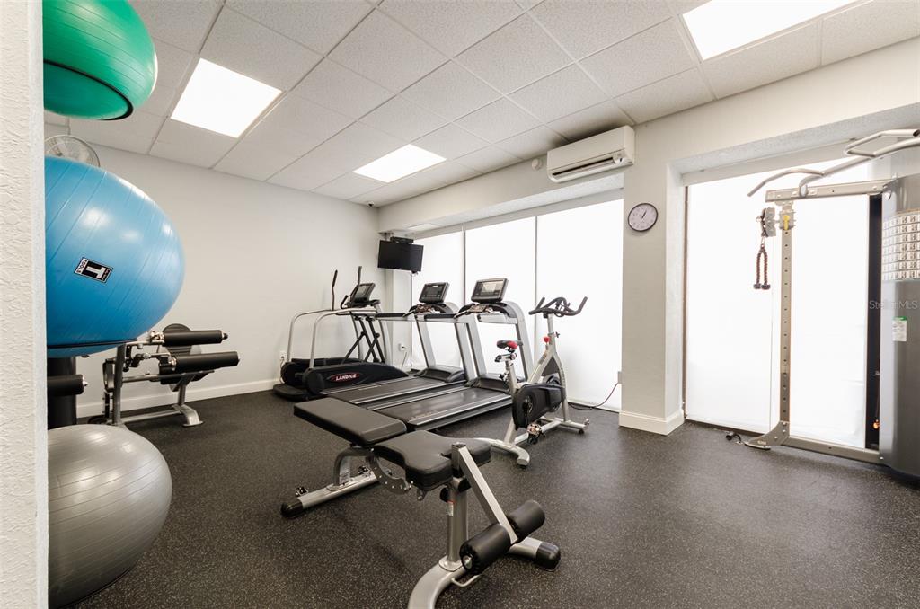 A gym room features exercise balls, treadmills, a stationary bike, and a weight machine — 450 S GULFVIEW BOULEVARD UNIT 405, CLEARWATER, FL