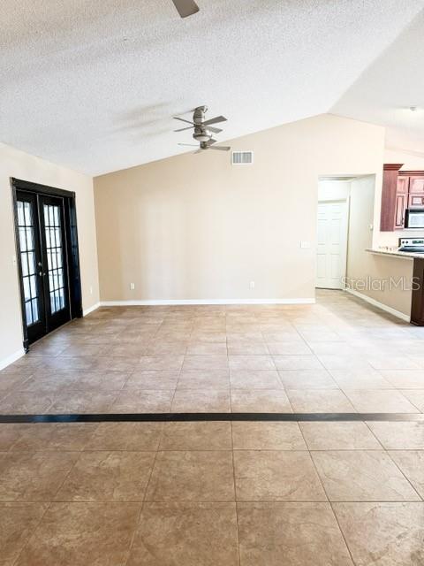 A spacious room features light-colored walls, a vaulted ceiling with a fan, and tiled floors — 9319 WOODBREEZE BOULEVARD, WINDERMERE, FL