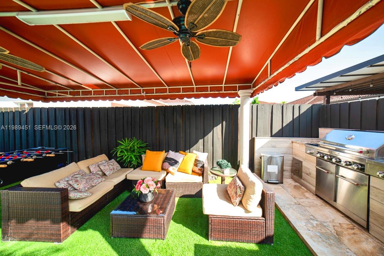 An outdoor patio features a covered seating area, artificial turf, and a stainless steel grill — 10254 SW 227th St # 0, Cutler Bay FL 33190, CUTLER BAY, FL