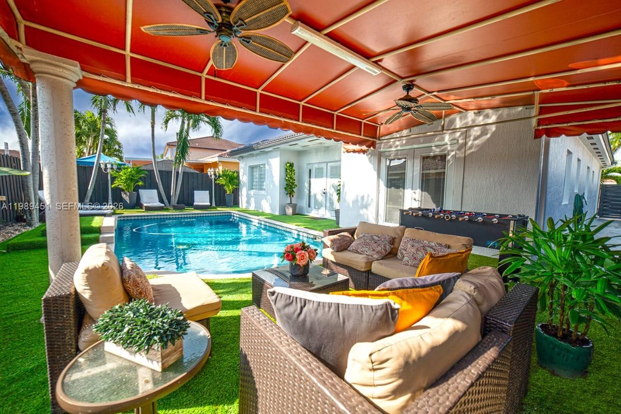 A patio with outdoor furniture, a swimming pool, and a red fabric awning — 10254 SW 227th St # 0, Cutler Bay FL 33190, CUTLER BAY, FL