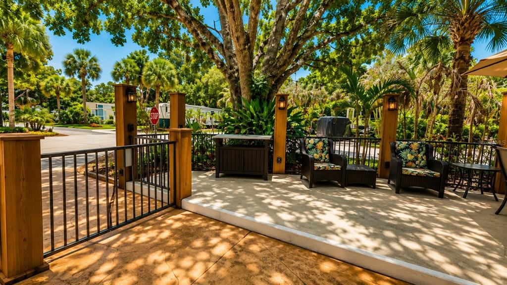 A paved outdoor patio features two wicker chairs, a storage cabinet, and wooden support posts — 219 E APPALOOSA TRAIL, RIVER RANCH, FL