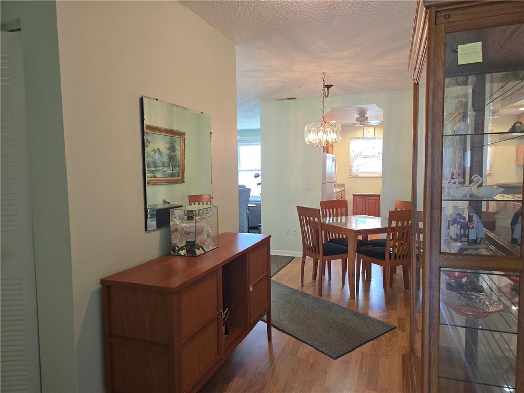 A dining area with a wooden table and chairs is visible through an open entryway — 5603 80TH STREET N UNIT 410, ST PETERSBURG, FL