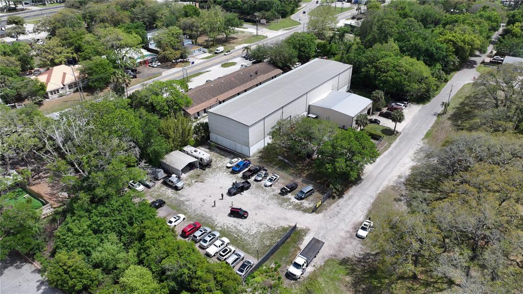 An aerial view shows a commercial building with a gravel parking lot and surrounding trees — 1324 MATTIE STREET, ST AUGUSTINE, FL