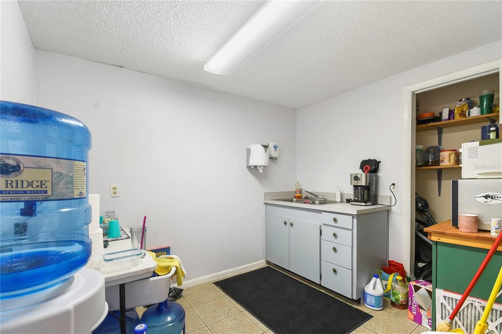 A utility room features a small sink, cabinetry, a water cooler, and an open pantry — 1324 MATTIE STREET, ST AUGUSTINE, FL
