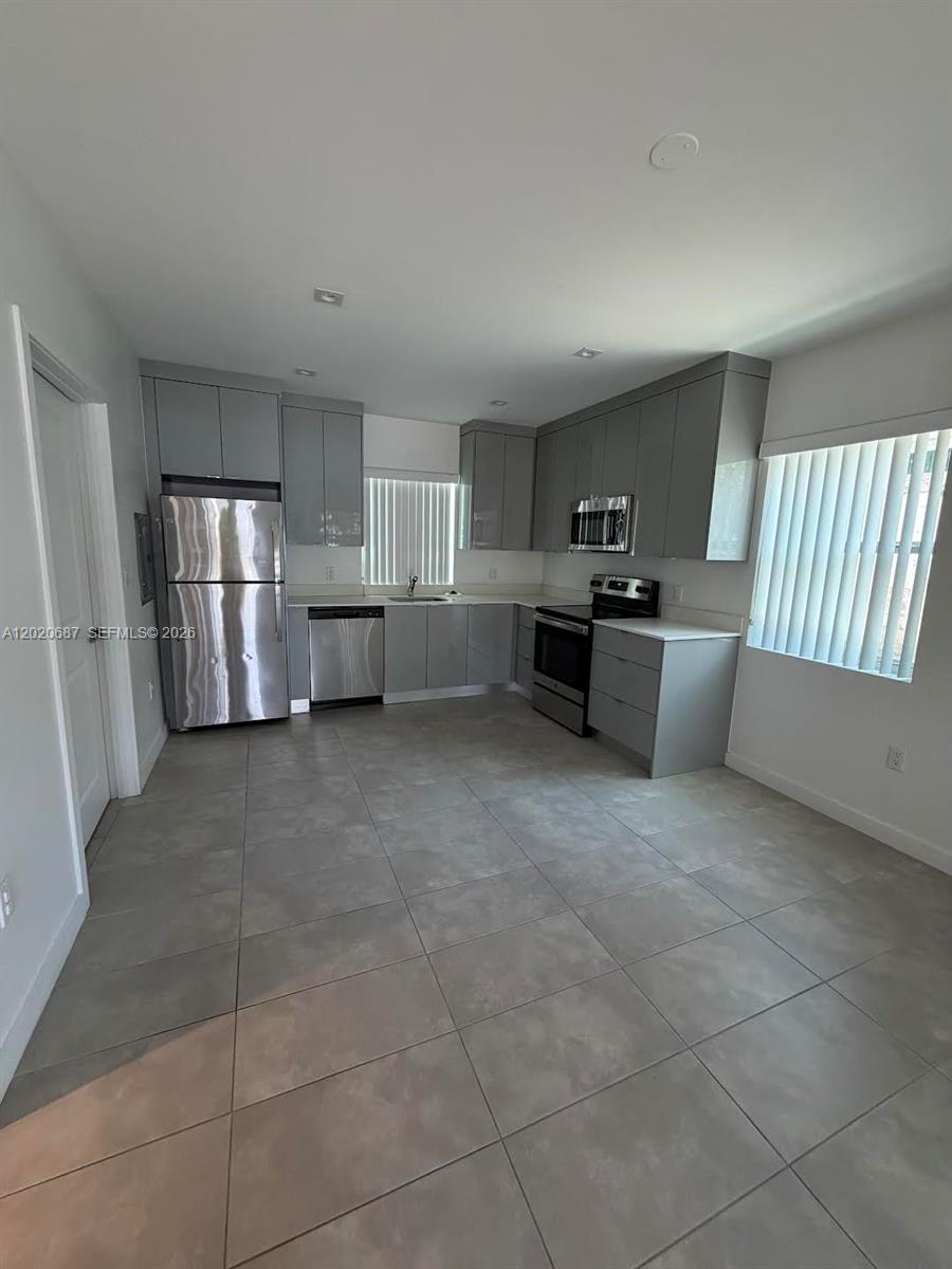 A kitchen features gray cabinets, stainless steel appliances, and large light-gray floor tiles — 2333 SW 58th Ave # 2333, Miami FL 33155, MIAMI, FL