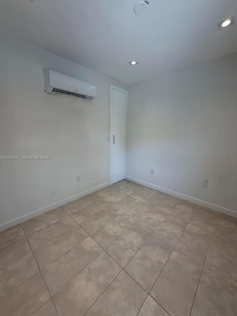 A small, empty room features light-colored tile flooring, white walls, and a wall-mounted air conditioner — 2333 SW 58th Ave # 2333, Miami FL 33155, MIAMI, FL