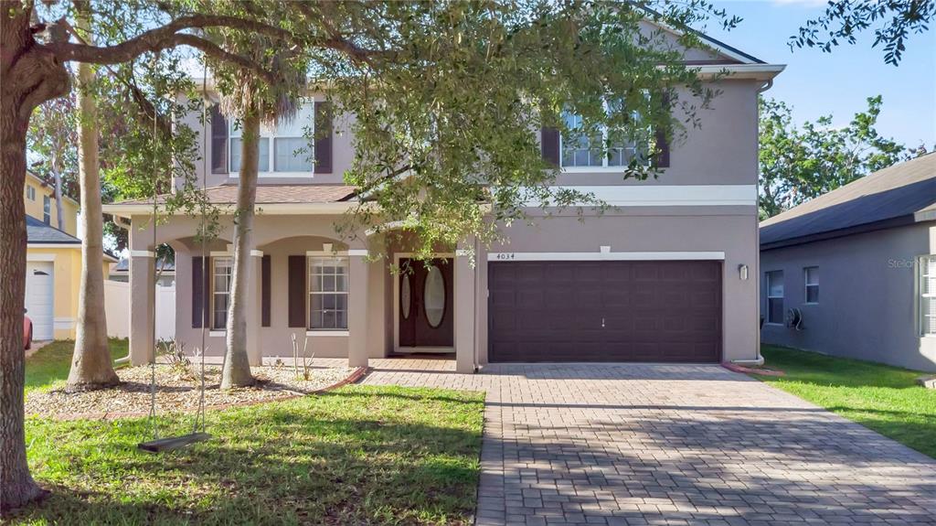 A two-story house with a paved driveway, a two-car garage, and a front porch — 4034 FELDSPAR TRAIL, ORLANDO, FL
