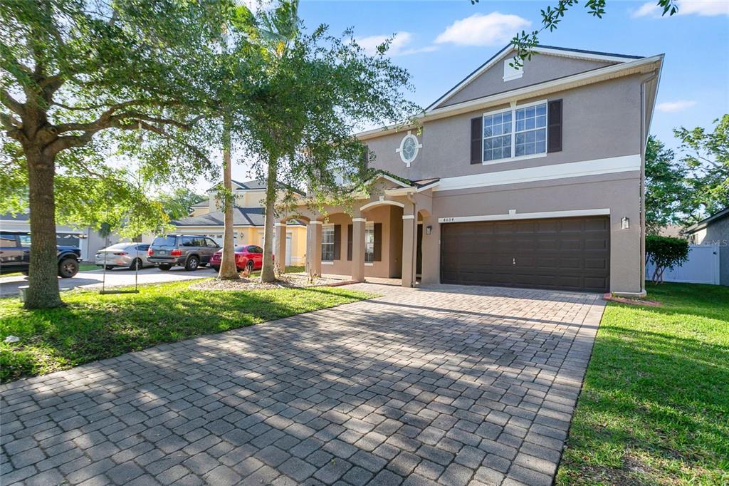 A two-story house with a paved driveway, a two-car garage, and a front porch — 4034 FELDSPAR TRAIL, ORLANDO, FL