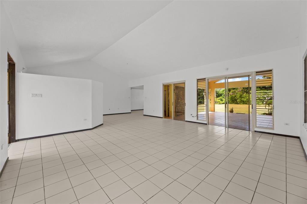 An empty living room with white walls, tiled floors, and sliding glass doors to a patio — 383 CAMINO LOS FLAMBOYANES, CIDRA, PR