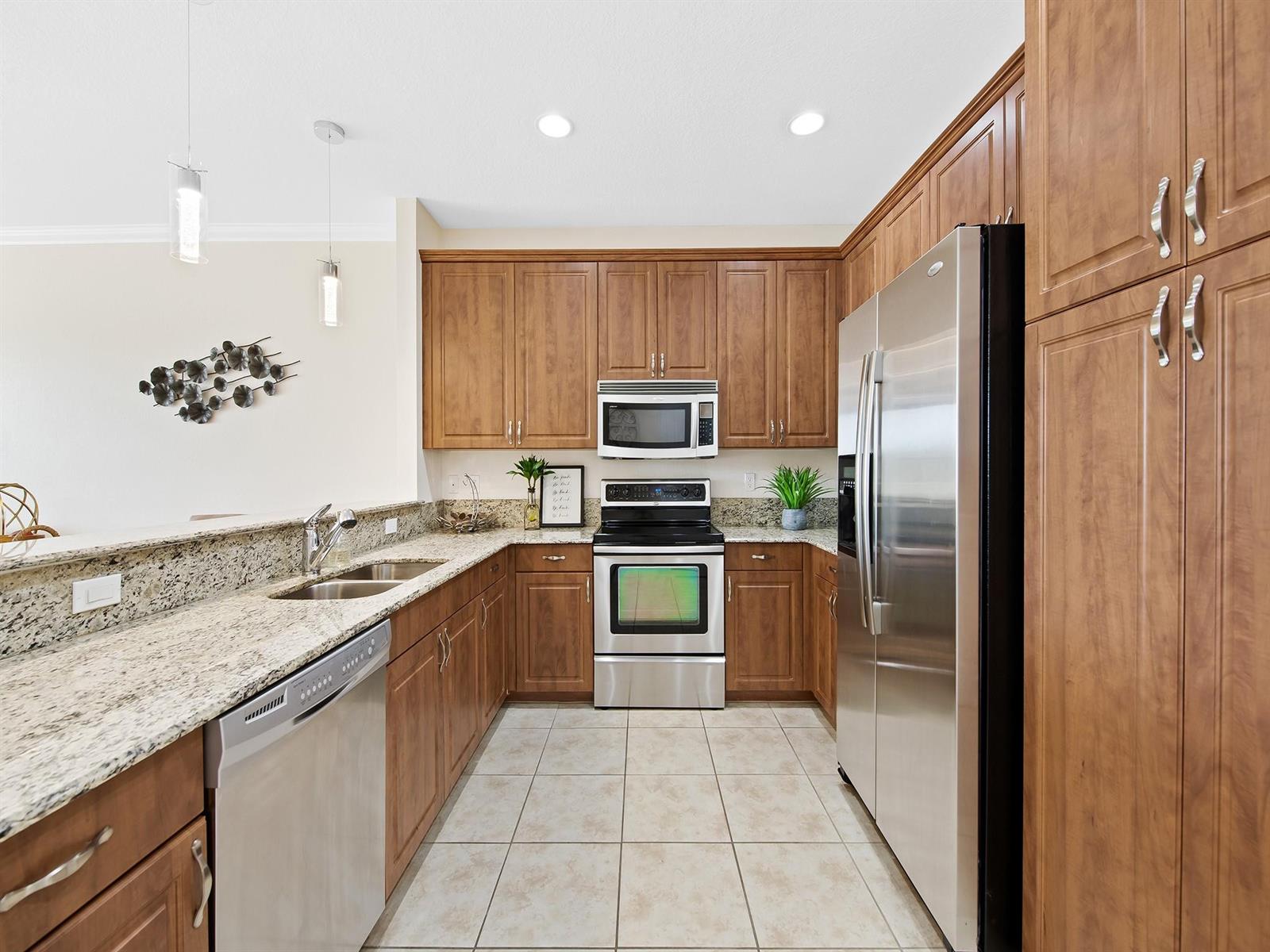 A bright kitchen with white cabinets, stainless steel appliances, and a view of a lake — 4792 Sundance Way # 4792, Davie FL 33328, DAVIE, FL