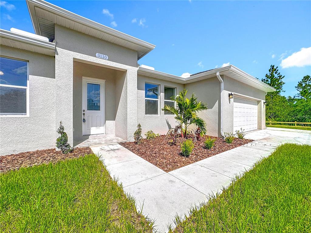 A single-story house exterior features a white front door, a garage, and a landscaped yard — 3110 CARNEGIE AVENUE, ORLANDO, FL