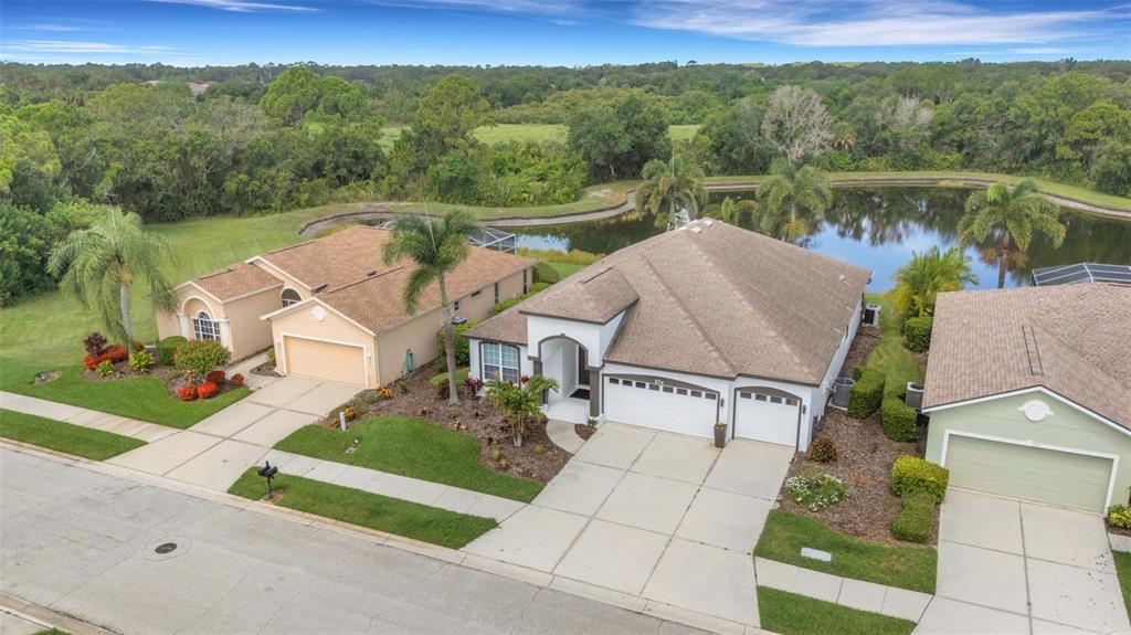 A living room with a white sectional sofa, tile flooring, and arched architectural columns — 374 LONDONDERRY DRIVE, SARASOTA, FL