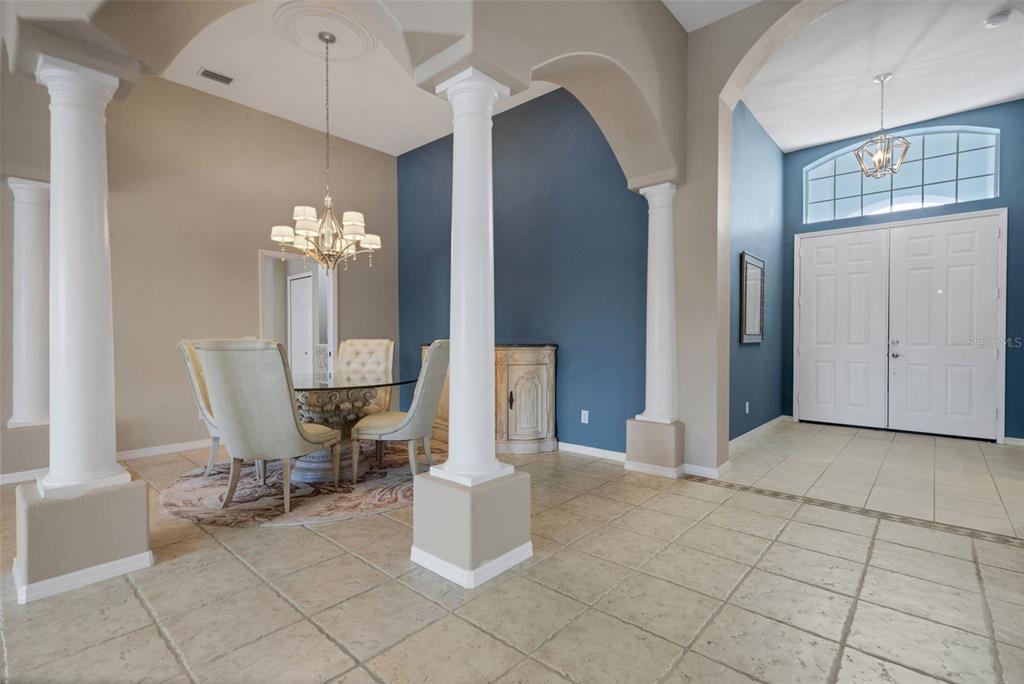 An open-concept living area features tile flooring, arched columns, and a blue-accented dining room — 374 LONDONDERRY DRIVE, SARASOTA, FL