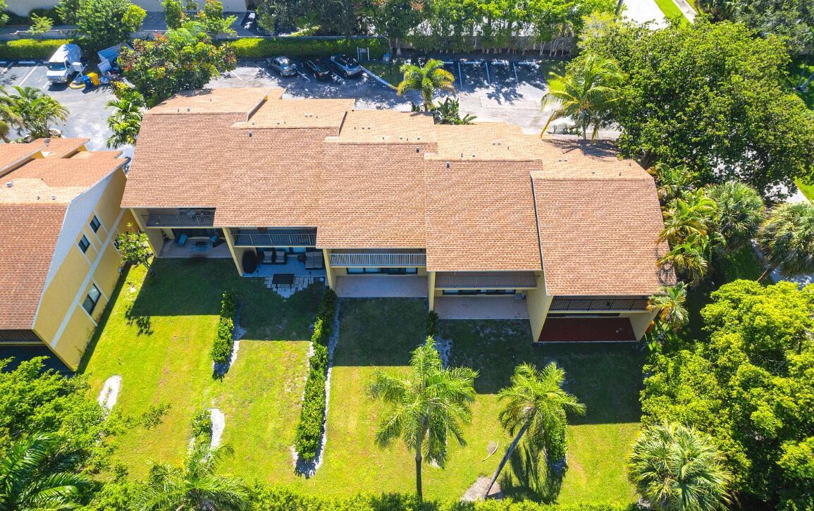 An aerial view of a multi-story apartment building with a brown roof and backyard lawn — 663 Dover Street # 10, Boca Raton FL 33487, BOCA RATON, FL